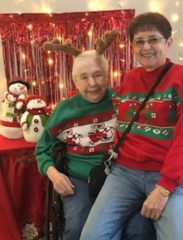 Assisted Living assisted living resident wearing reindeer antlers smiling
