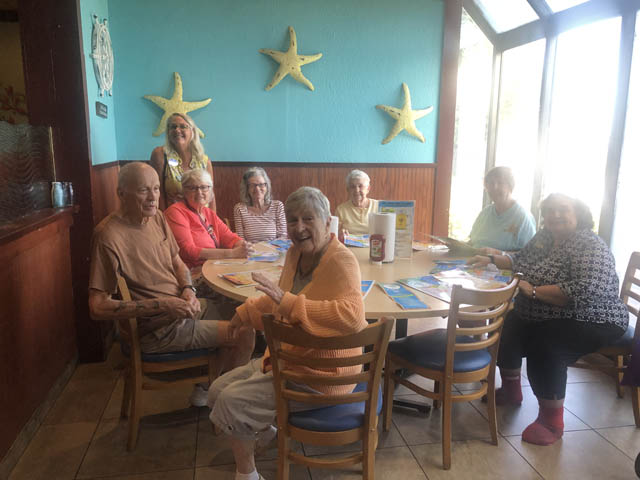 Header assisted living seniors at lunch outing